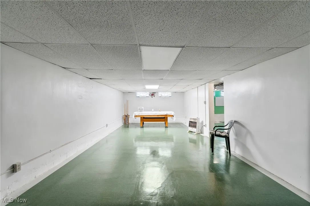 Rec room with a drop ceiling, billiards table, and finished concrete floors