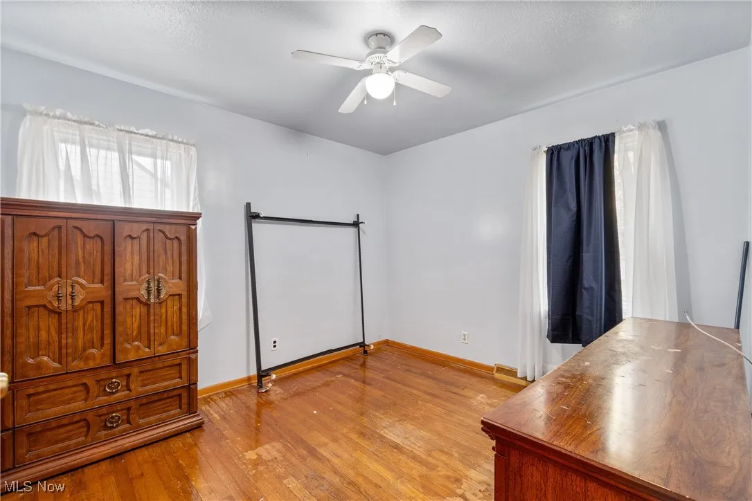 Unfurnished bedroom with light wood-style flooring, ceiling fan, and a textured ceiling