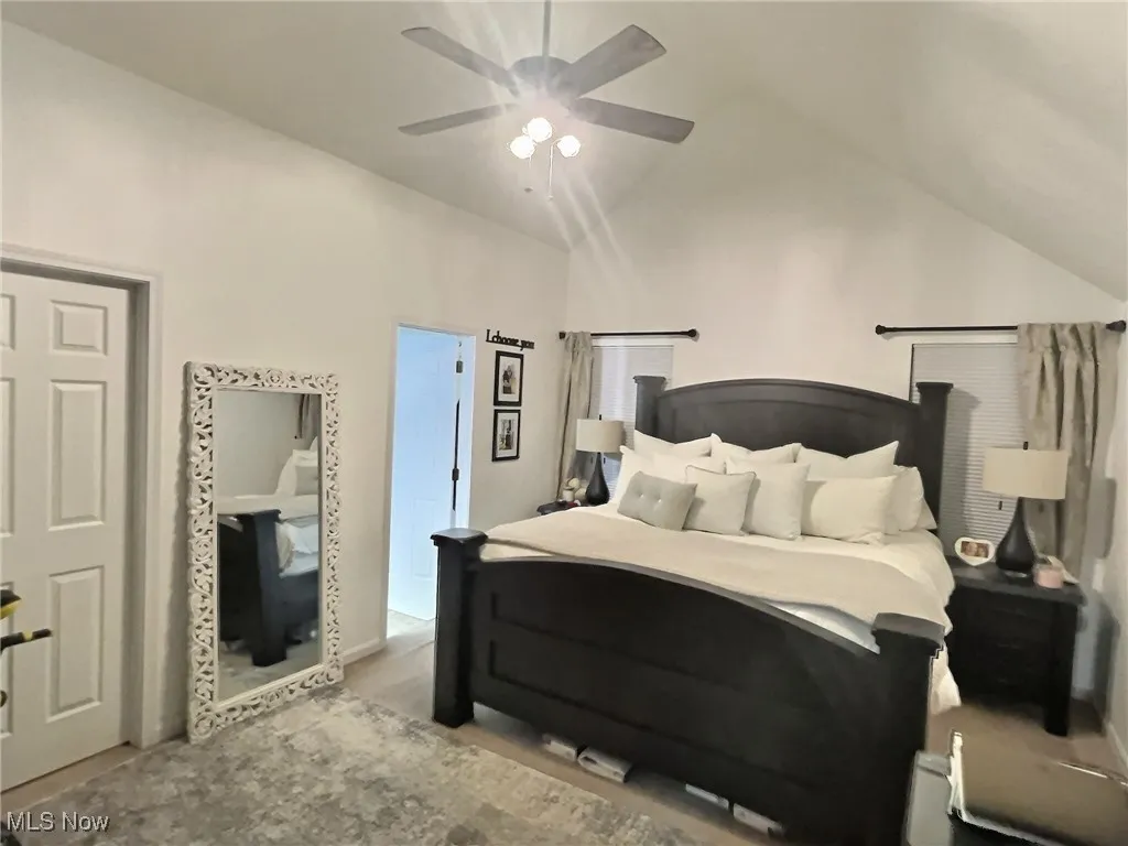 Bedroom with vaulted ceiling and a ceiling fan