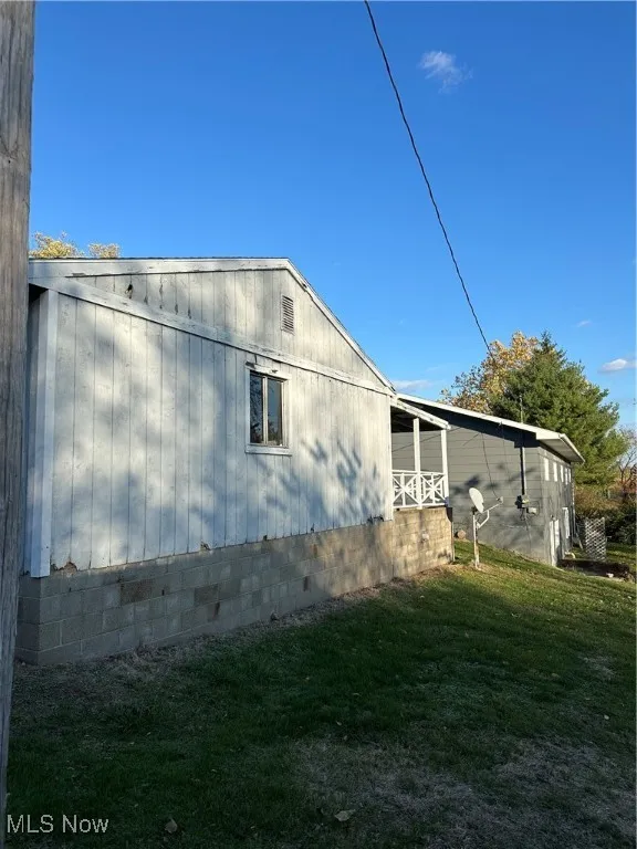 Back view of garage & home with a lawn