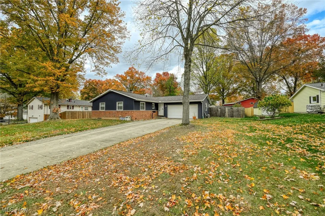 Ranch-style home with driveway, a garage, and brick siding