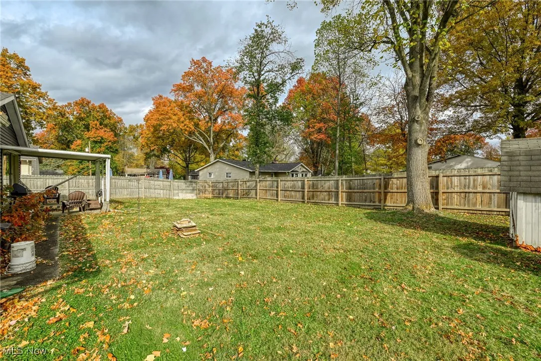 Fenced backyard with view of scattered trees