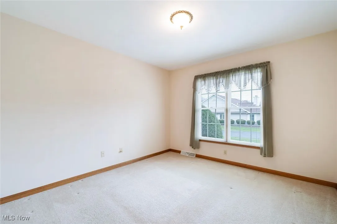 Empty room with carpet and baseboards