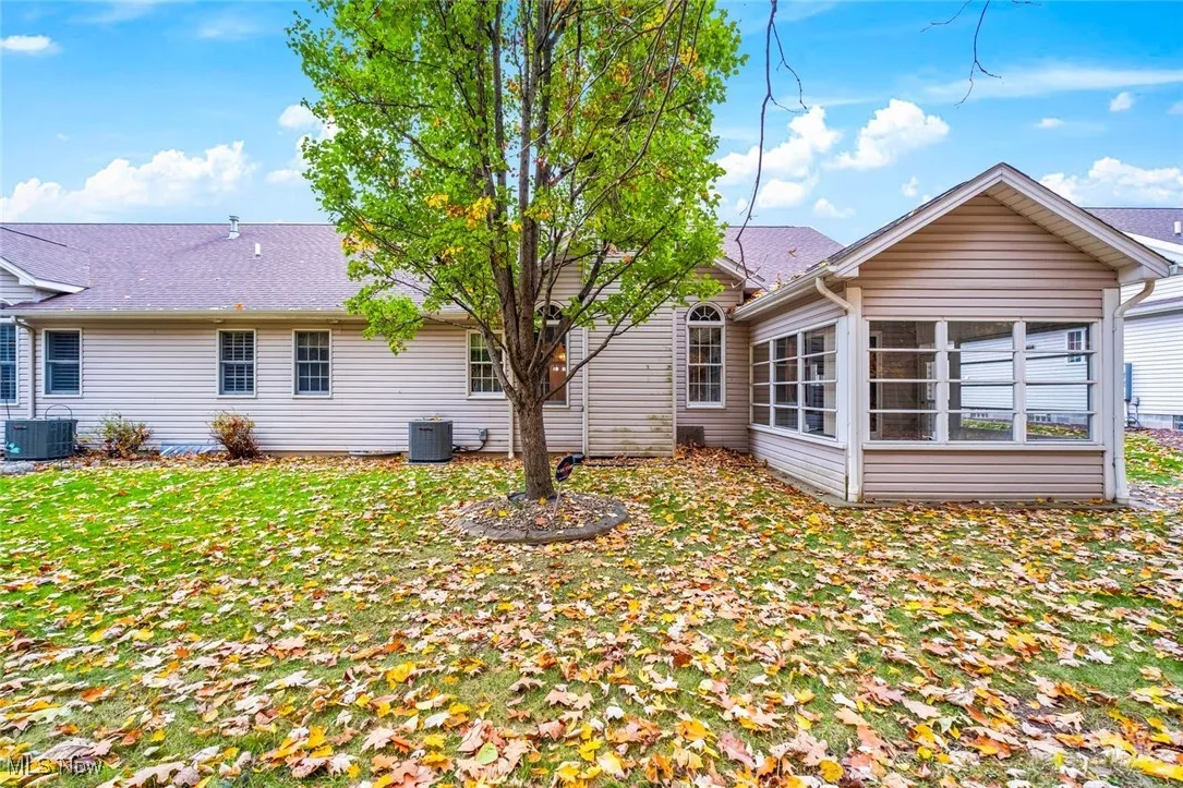 Rear view of property featuring a sunroom and a yard
