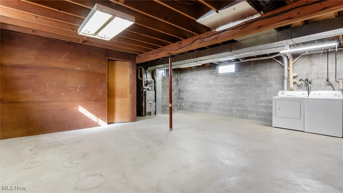 Below grade area with washer and clothes dryer and heating unit