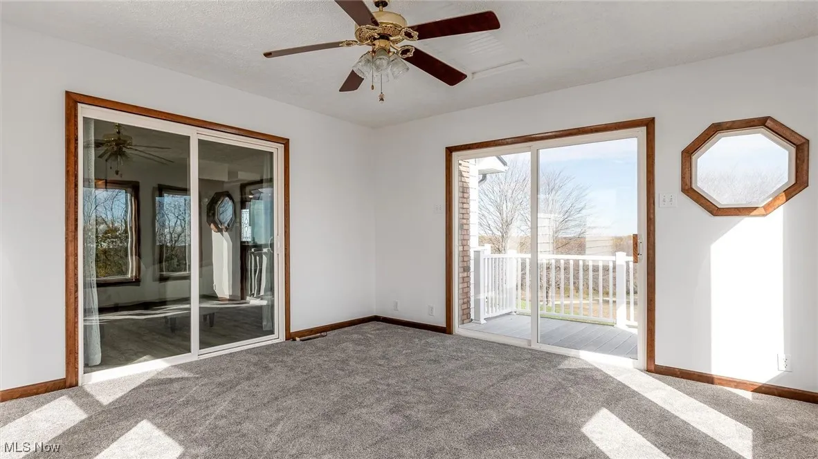 Carpeted spare room featuring ceiling fan and a textured ceiling