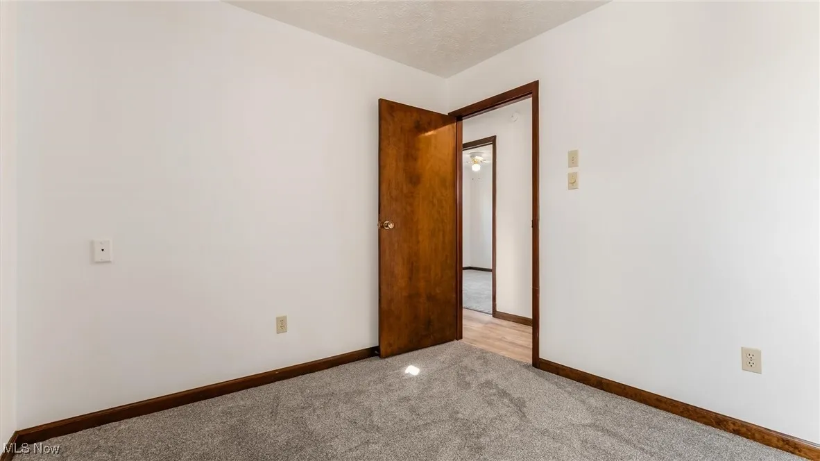 Unfurnished room with carpet flooring and a textured ceiling