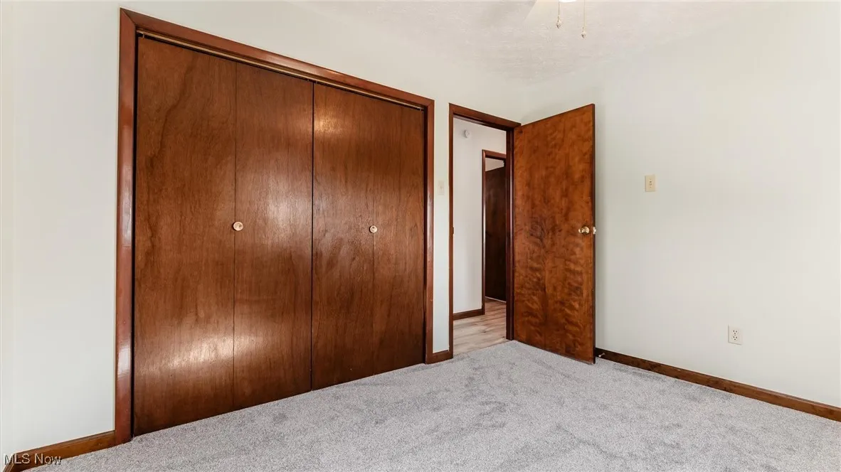 Bedroom with carpet, a closet, and a textured ceiling