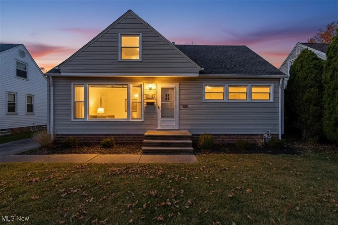 Bungalow-style home with a front yard and roof with shingles