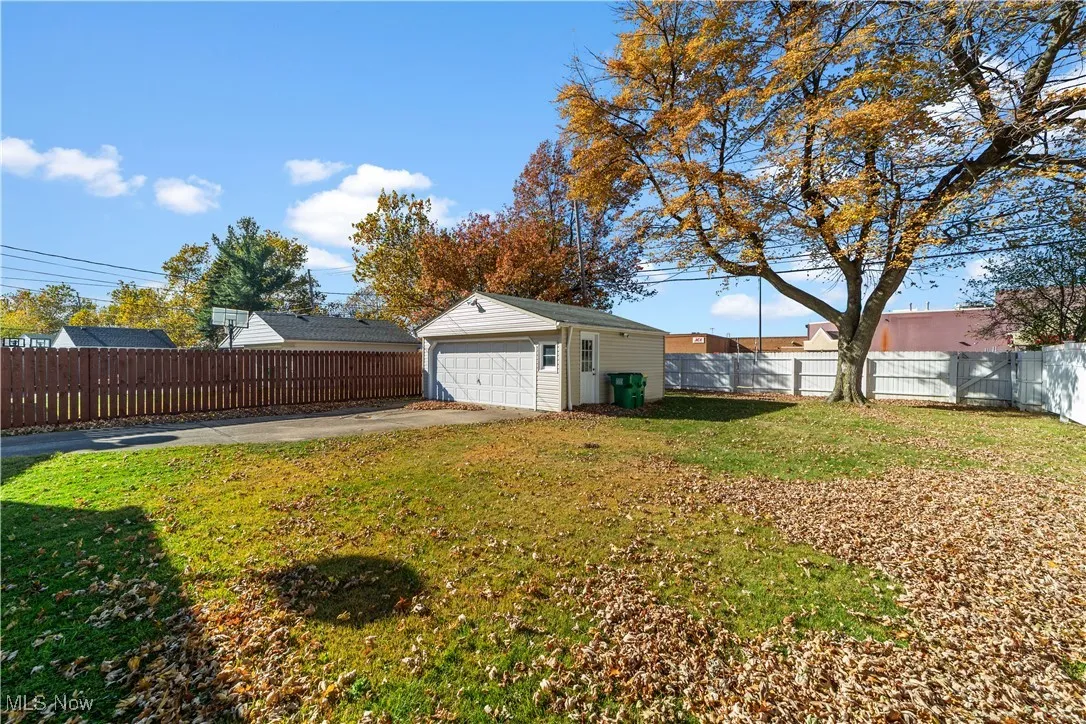 Fenced backyard with an outdoor structure and a detached garage