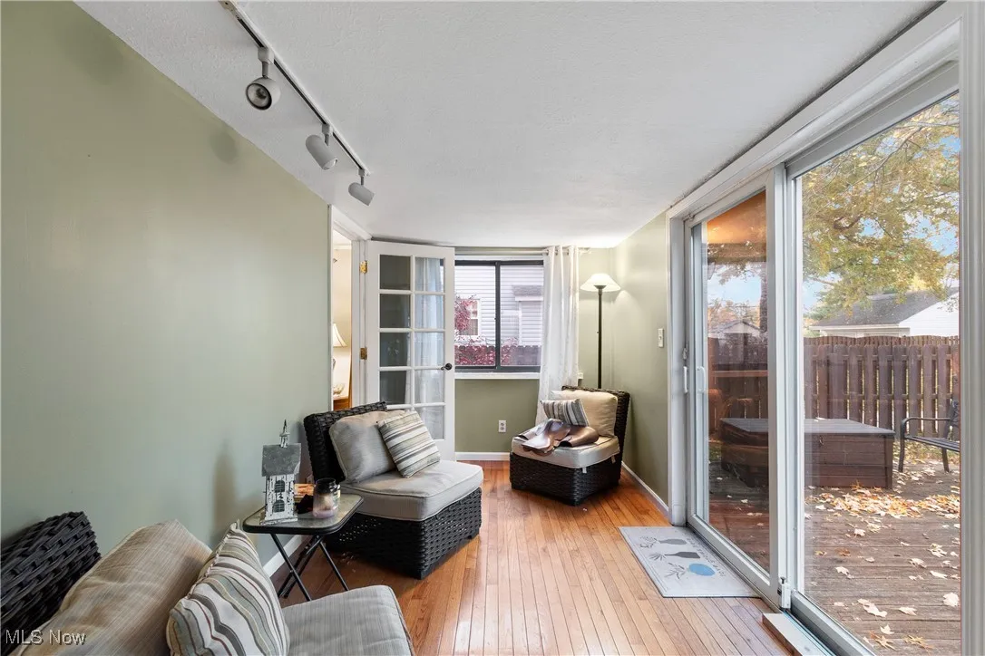 Living area featuring wood-type flooring and rail lighting