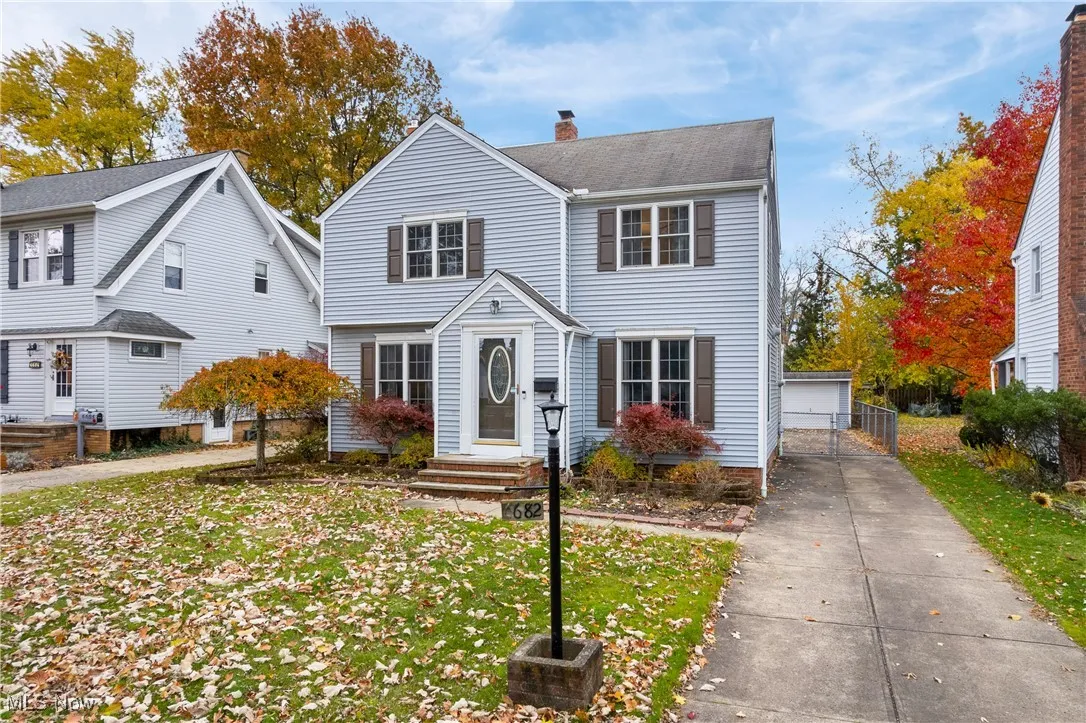 View of front facade featuring a chimney, an outdoor structure, and a garage