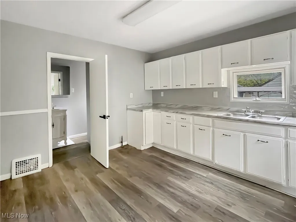 Laundry area featuring light wood-type flooring and baseboards