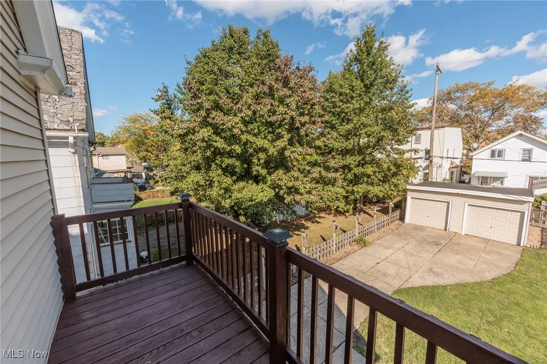 Wooden balcony with an outdoor structure and a view of the back yard