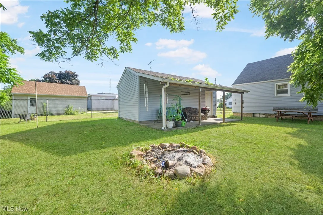 Back of property with an outdoor fire pit and a patio