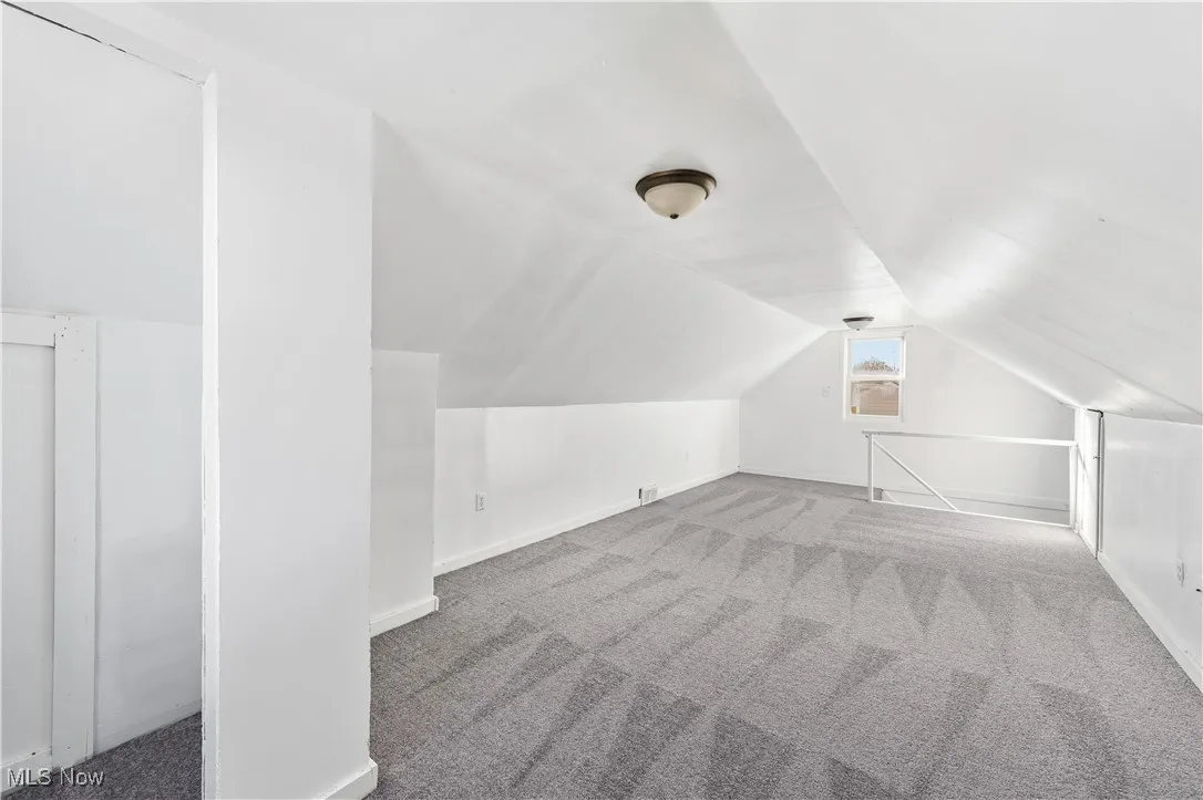 bedroom with carpet floors and lofted ceiling
