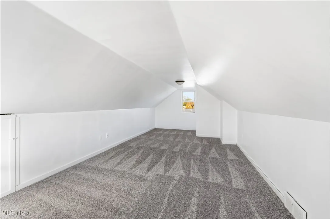 bedroom with carpet, lofted ceiling, and a baseboard radiator
