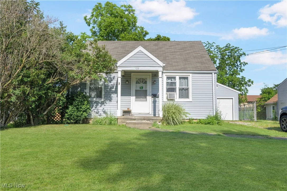 View of front of home with a garage and a shingled roof