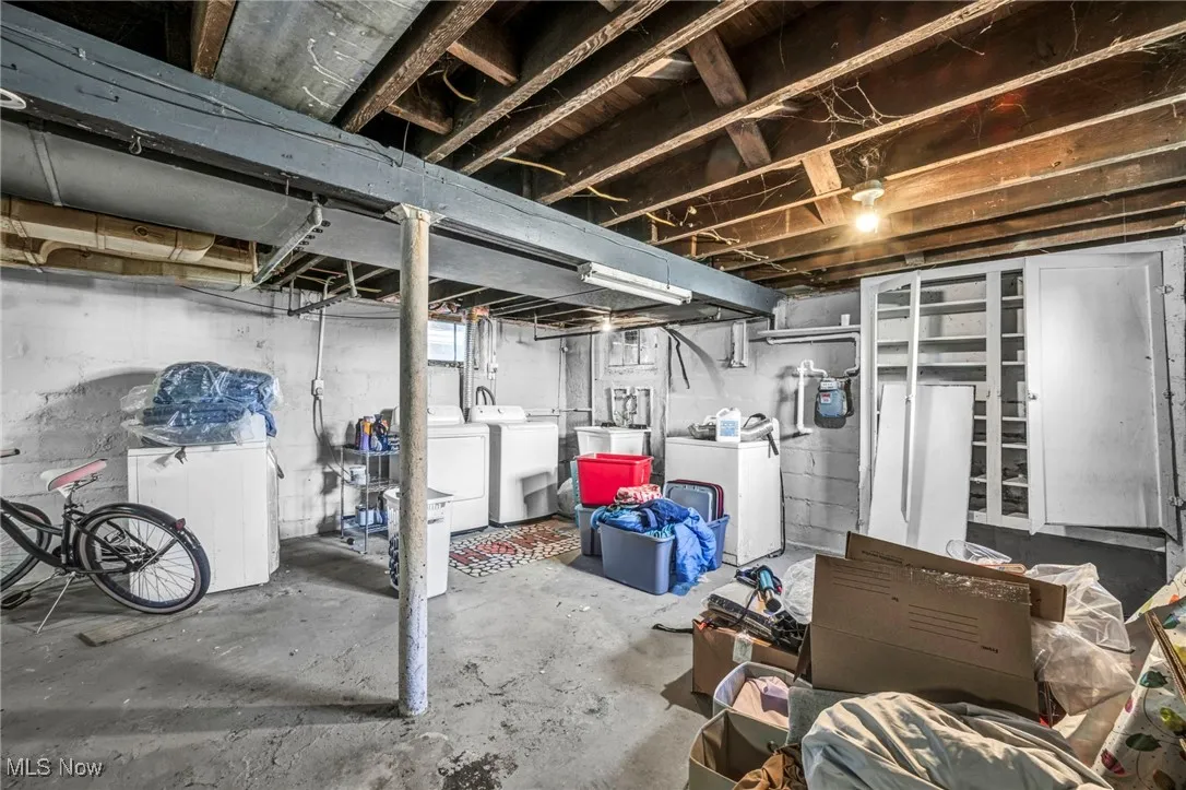 Unfinished basement with washer and clothes dryer and gas meter