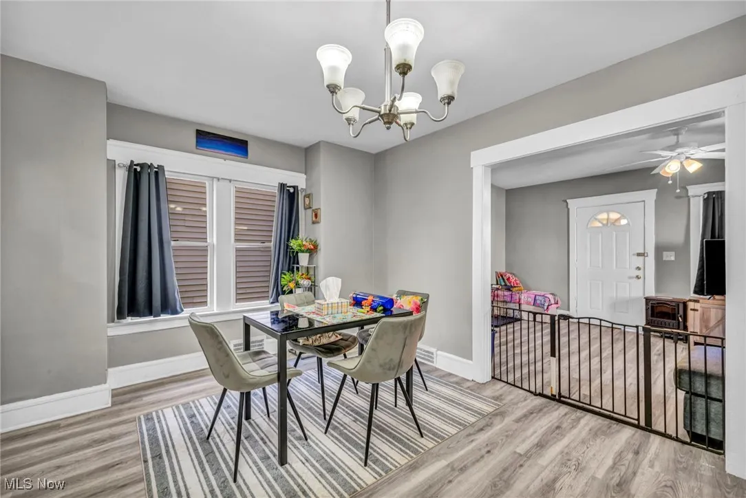 Dining room featuring light wood-type flooring, a chandelier, and a ceiling fan