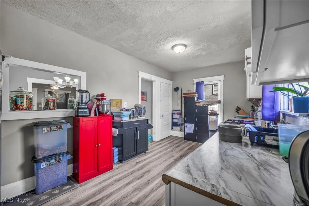 Office area featuring a textured ceiling, light wood-style flooring, and a chandelier