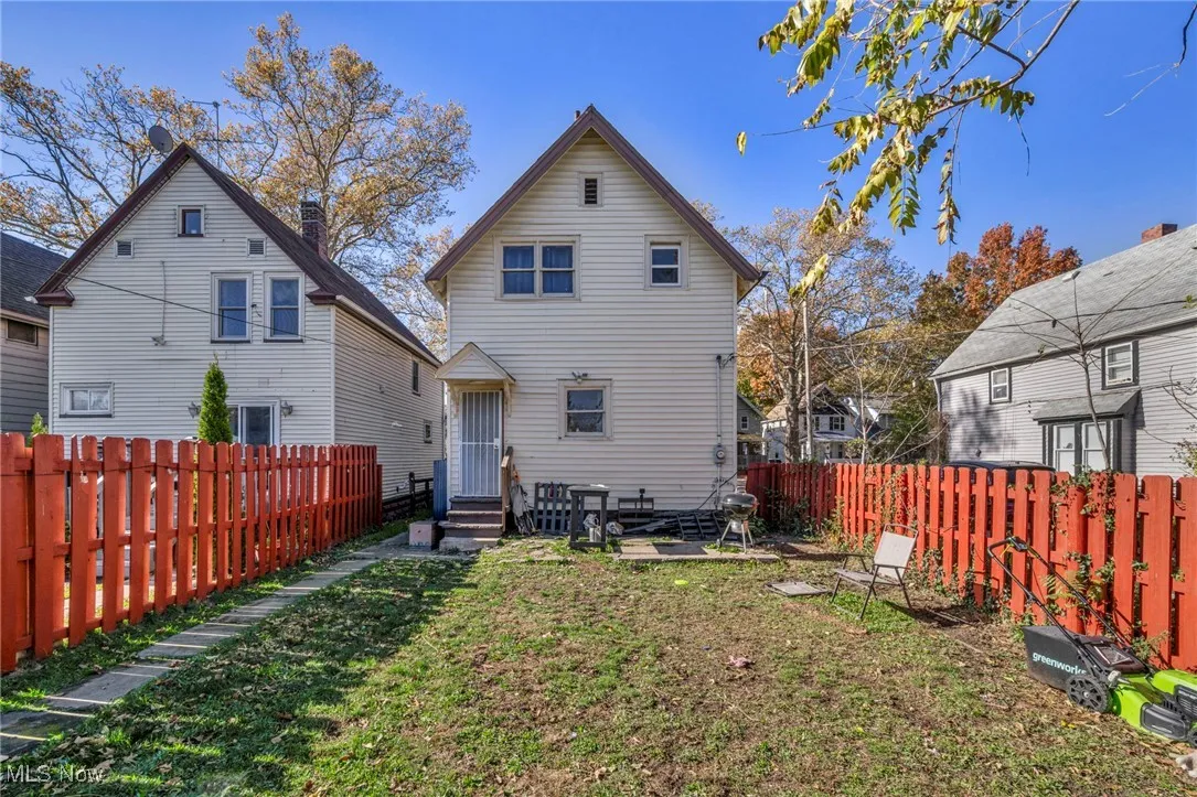Back of house with a fenced backyard and entry steps