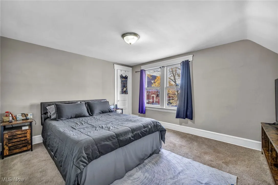 Bedroom featuring carpet flooring and lofted ceiling