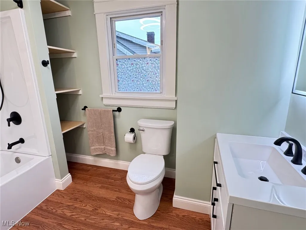 Full bathroom with dark wood finished floors, vanity, and bathtub / shower combination