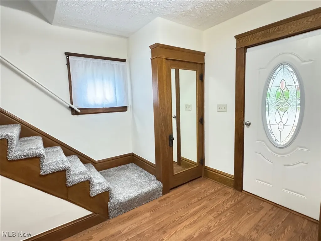 Entryway featuring a textured ceiling and wood finished floors