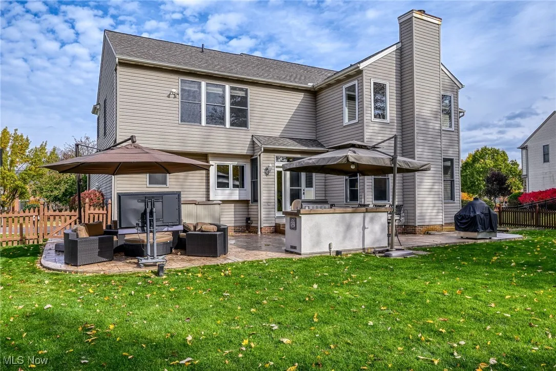 Back of house with a fenced backyard, a patio area, an outdoor hangout area, a chimney, and roof with shingles