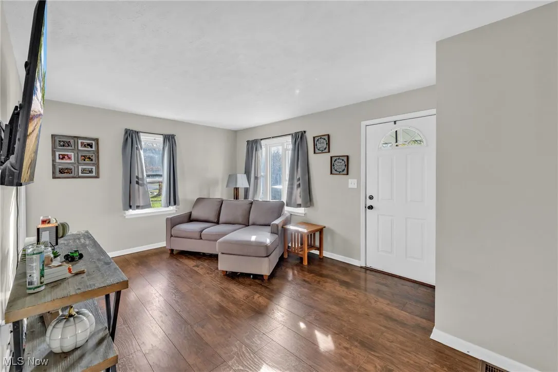 Living room featuring baseboards and dark wood-style floors