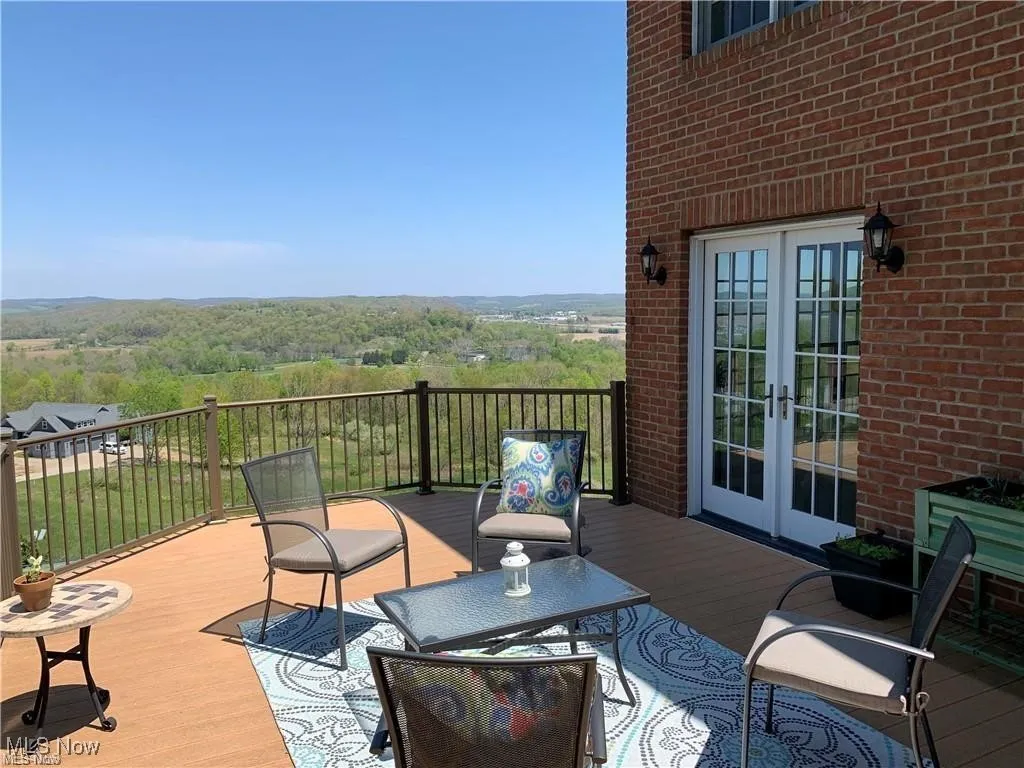 Wooden terrace featuring french doors and a view of trees