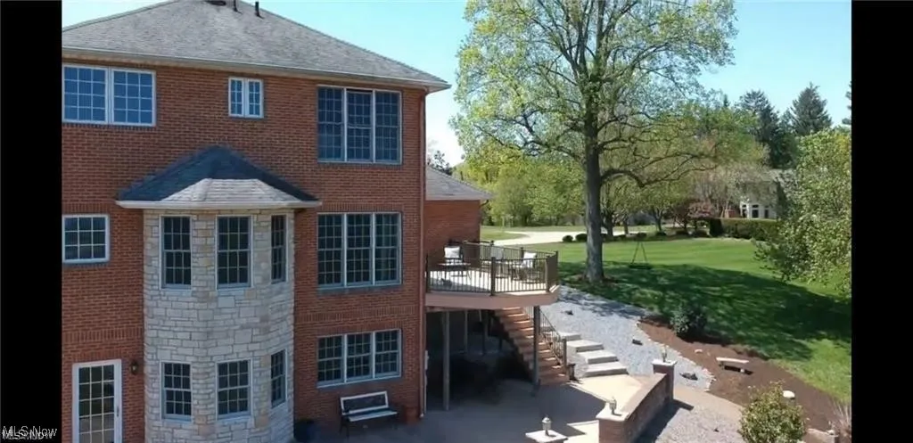 Rear view of house with stairway, a patio area, a lawn, a deck, and brick siding
