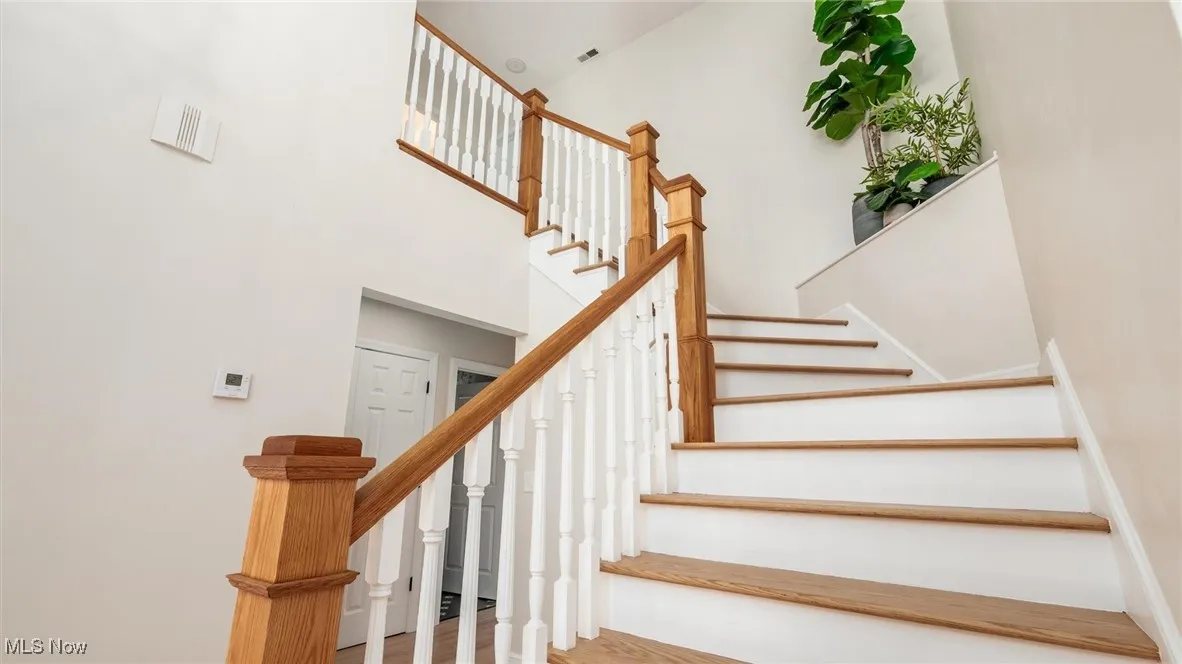 Stairway featuring wood finished floors and a high ceiling