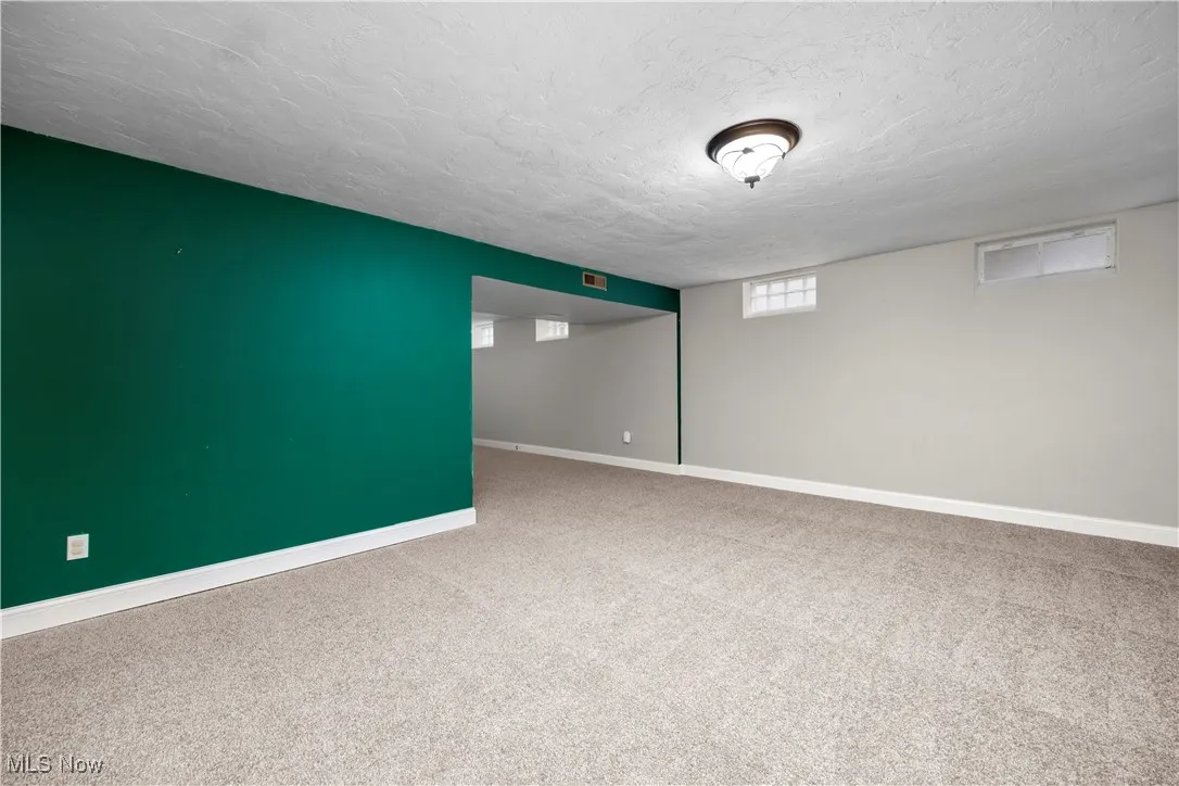 Basement featuring carpet floors and a textured ceiling