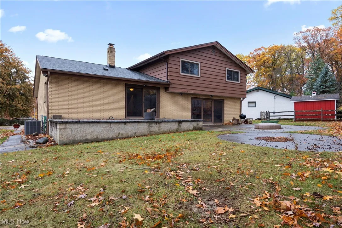 Back of property with brick siding, a chimney, and a patio area