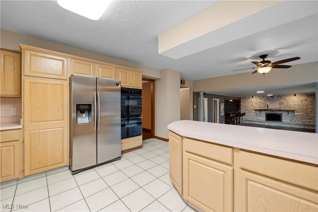 Kitchen featuring stainless steel fridge with ice dispenser, light countertops, and light brown cabinetry