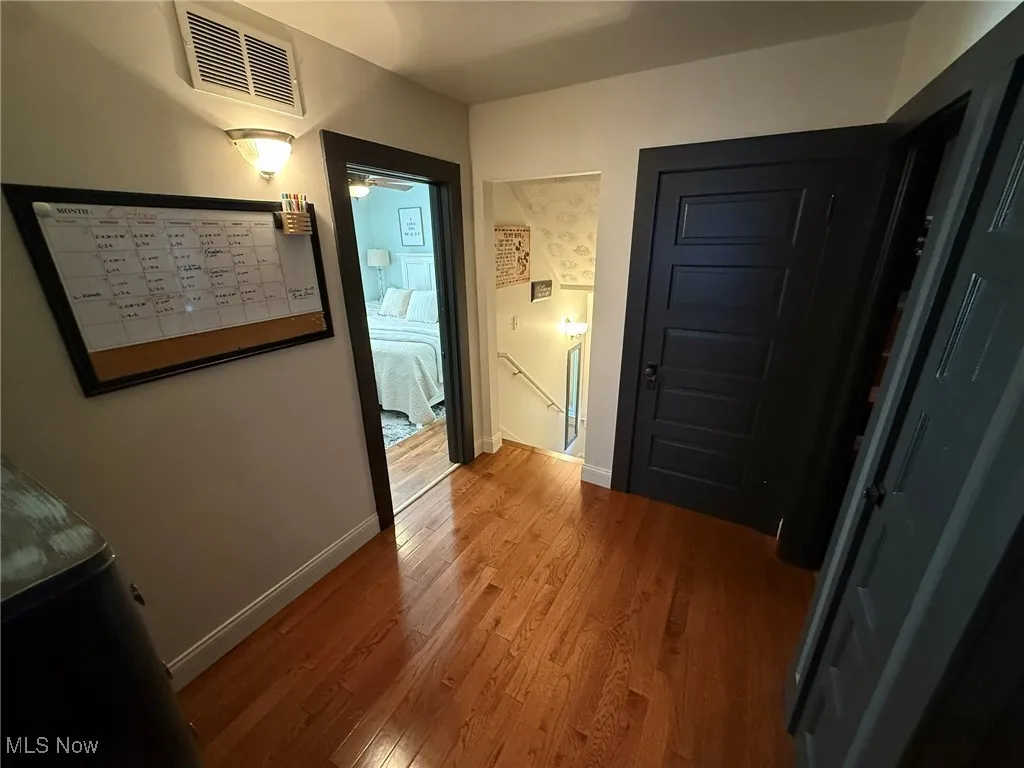 Hall featuring light wood-style flooring and an upstairs landing