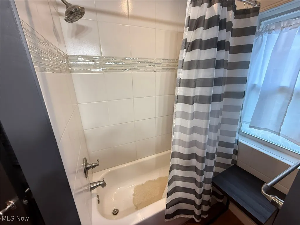 Bathroom featuring shower / bathtub combination with curtain