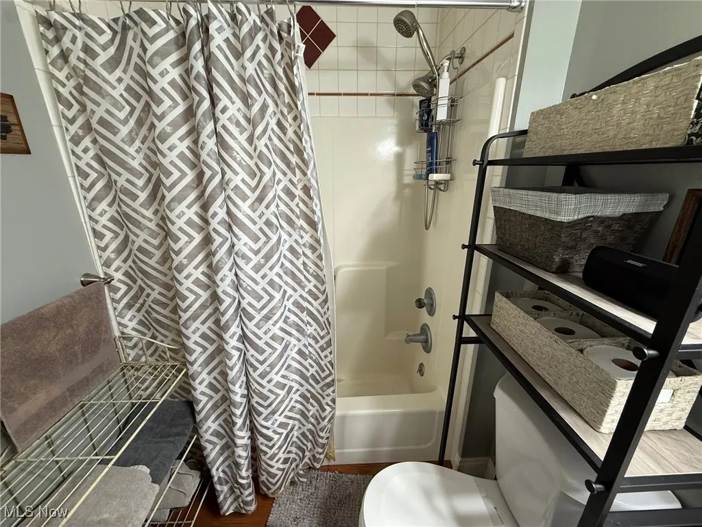 Full bathroom with shower / tub combo with curtain and toilet