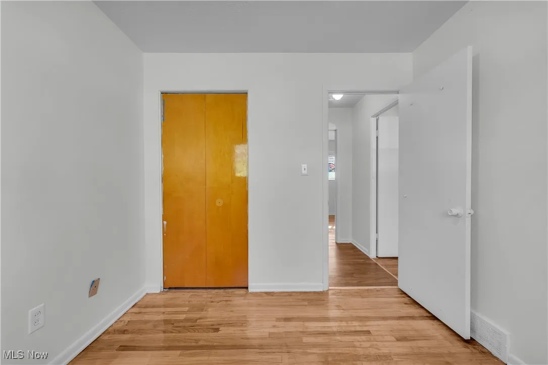 Unfurnished bedroom with light wood finished floors and a closet