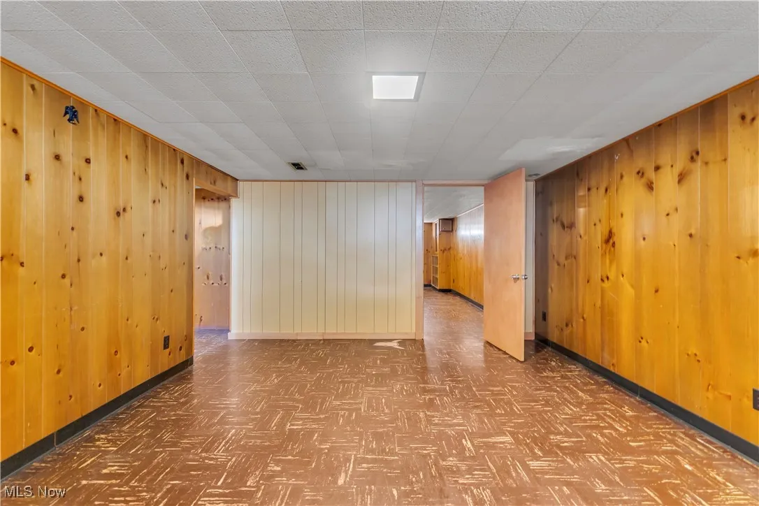 Spare room featuring wooden walls and baseboards