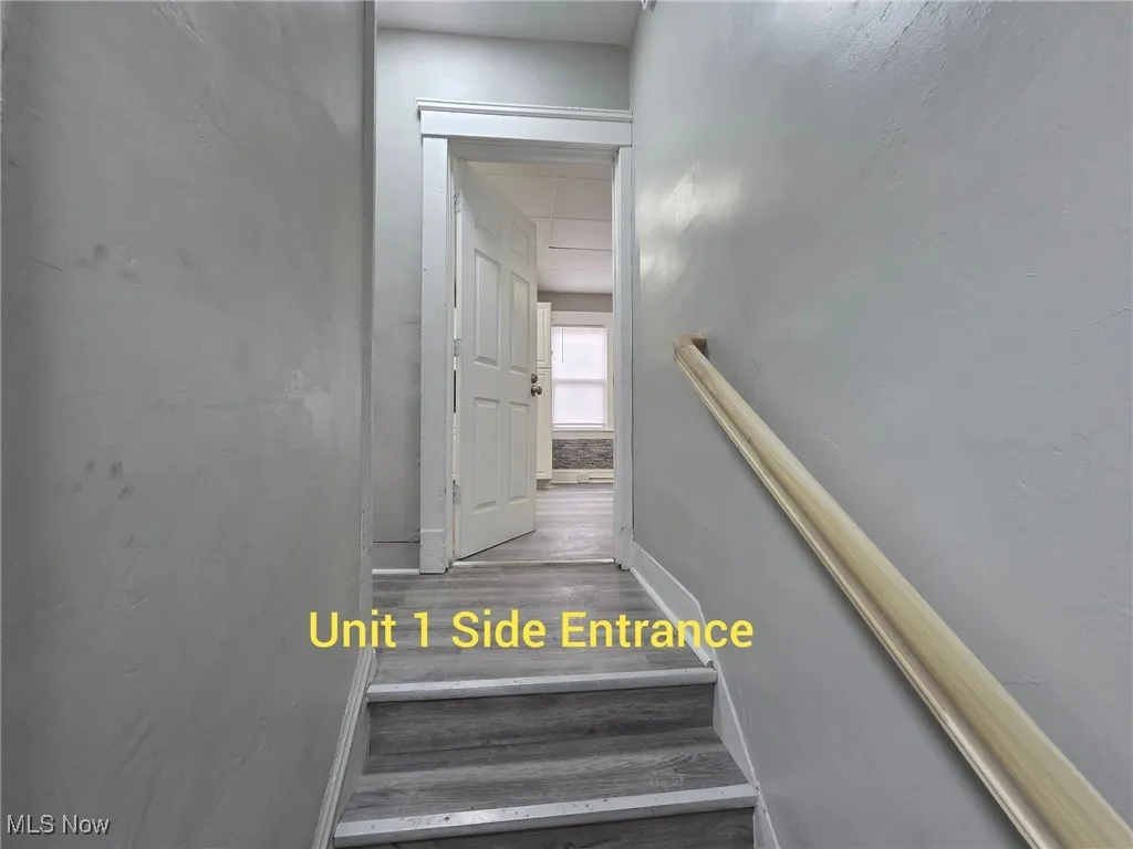 Staircase with wood finished floors and baseboards