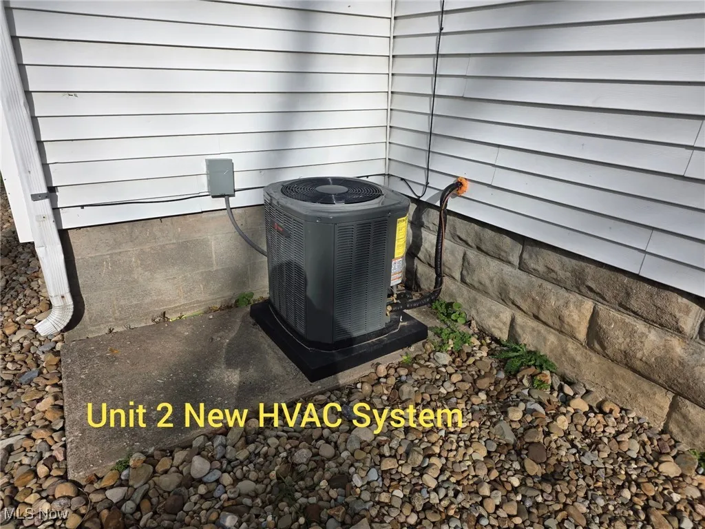 Exterior view of a central AC unit and a wood stove