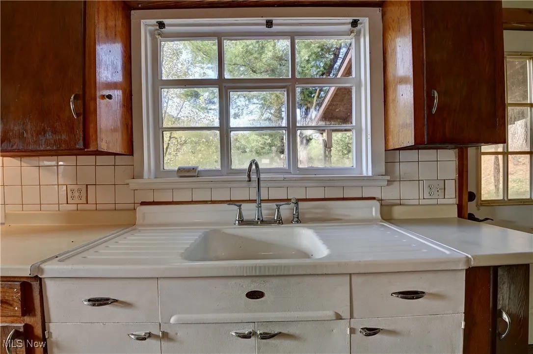 Kitchen featuring tasteful backsplash and light countertops
