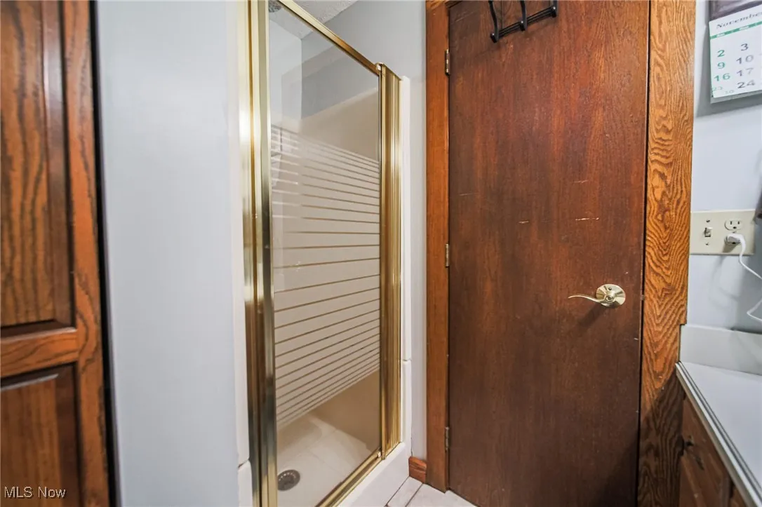 Full bathroom with vanity and a shower stall