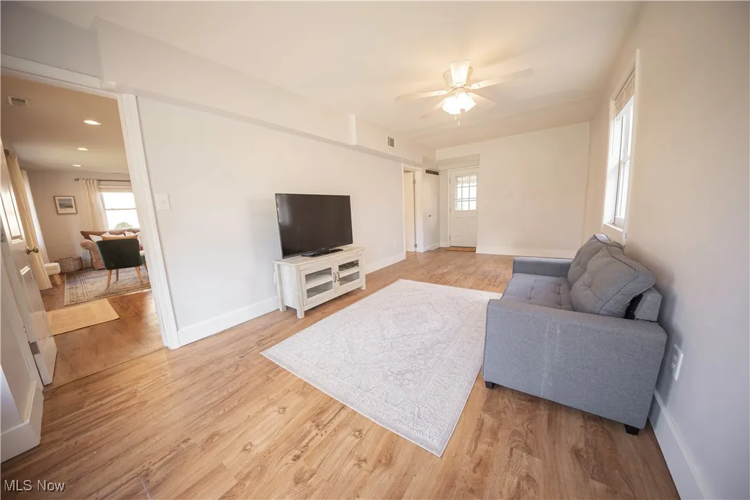 Living room featuring light wood-type flooring and ceiling fan