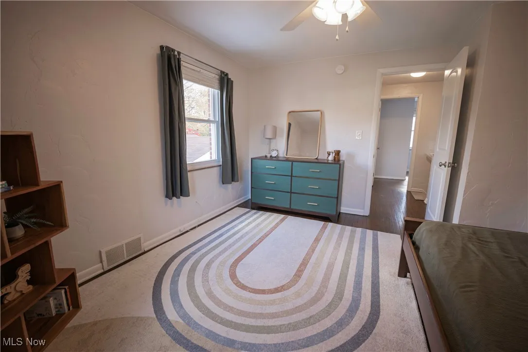 Bedroom with ceiling fan and a textured wall