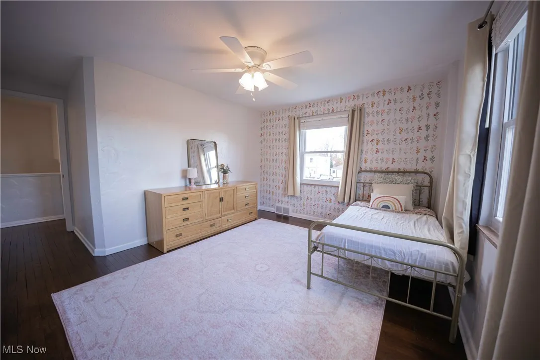 Bedroom with dark wood finished floors and a ceiling fan