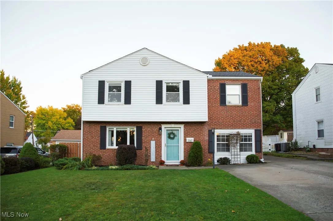 Colonial-style house featuring a front lawn and brick siding